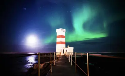 Northern Lights over a lighthouse in Iceland, displayed at Reykjavik Northern Lights Museum
