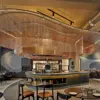 Mýrín Restaurant at Grandi Center Hotels, displaying a sophisticated setup with dark furniture, artistic light fixtures, and an inviting dining space.
