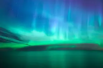 Northern lights over ocean from Vik i Myrdal Iceland.